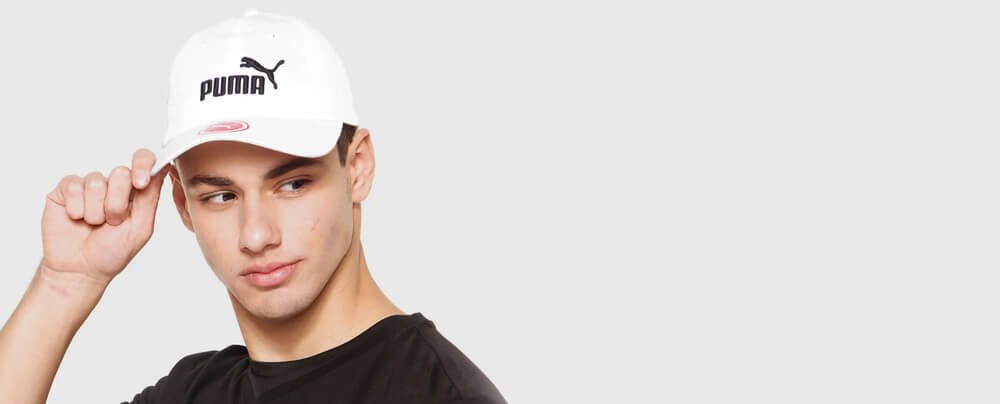 Imagem de um homem usando boné branco e blusa preta