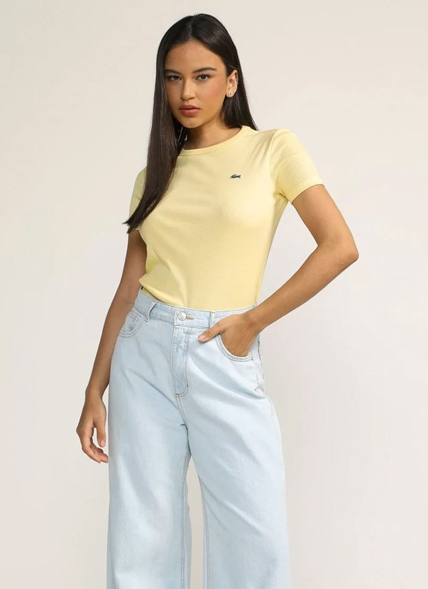 modelo posando pra foto usando look com camiseta amarela