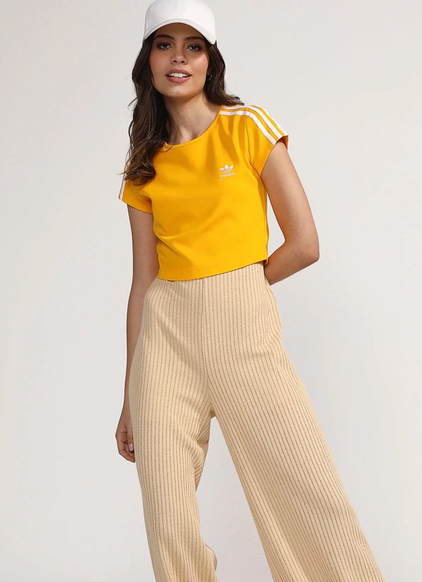 modelo posando pra foto usando look com camiseta amarela