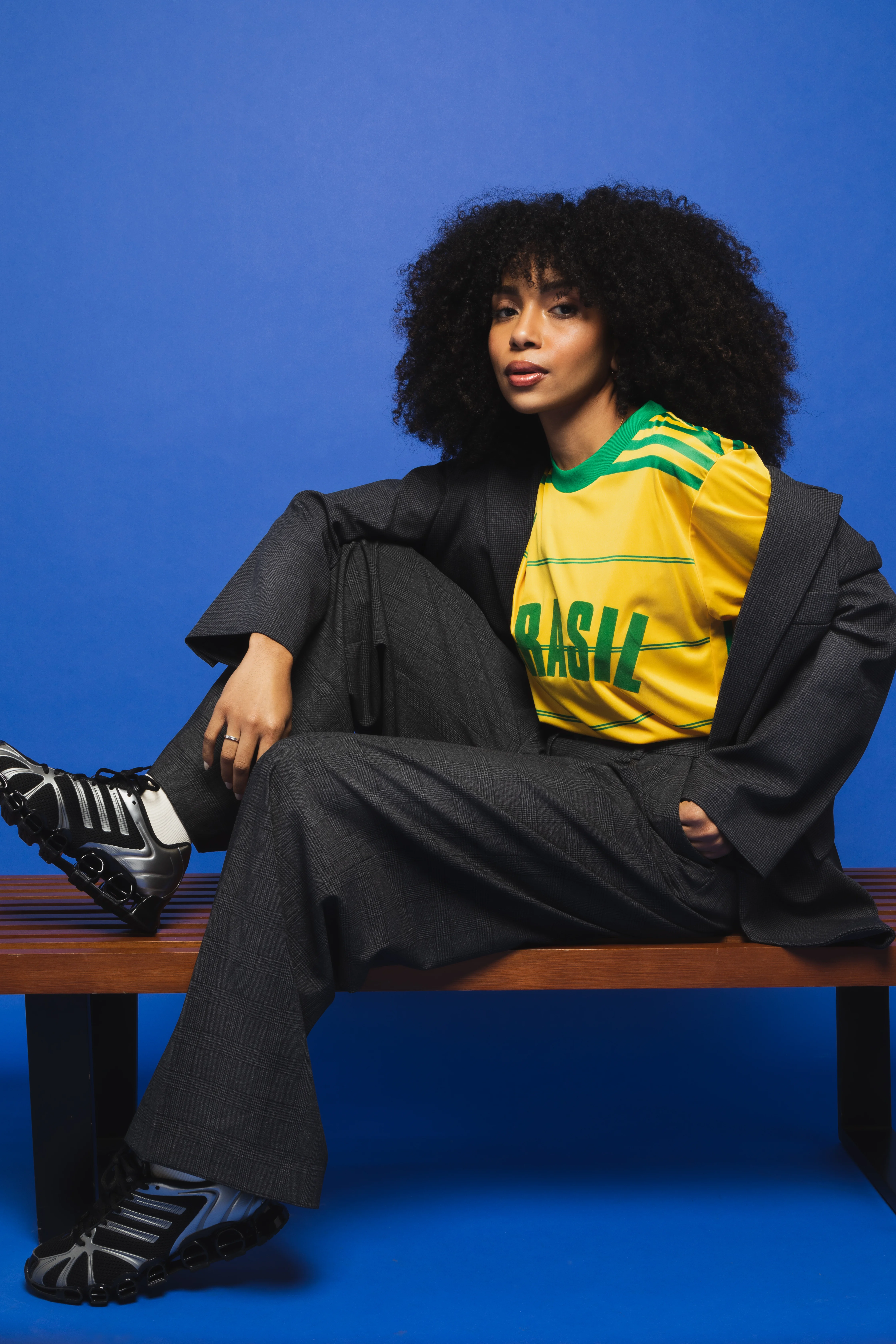 Melher com camiseta amarela do Brasil, blazer, calça alfaiataria e tênis.