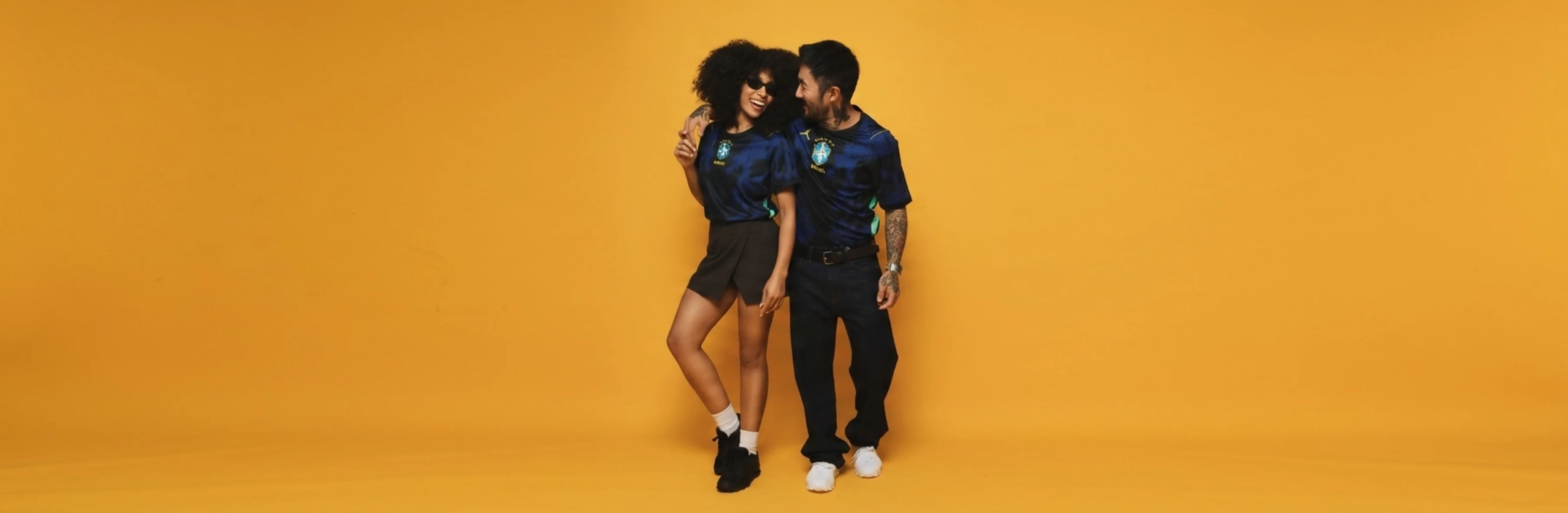 Casal com look casual utilizando a camisa do Brasil.