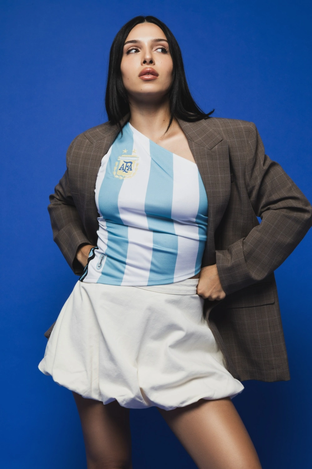 Mulher com camiseta azul da Argentina e blazer.
